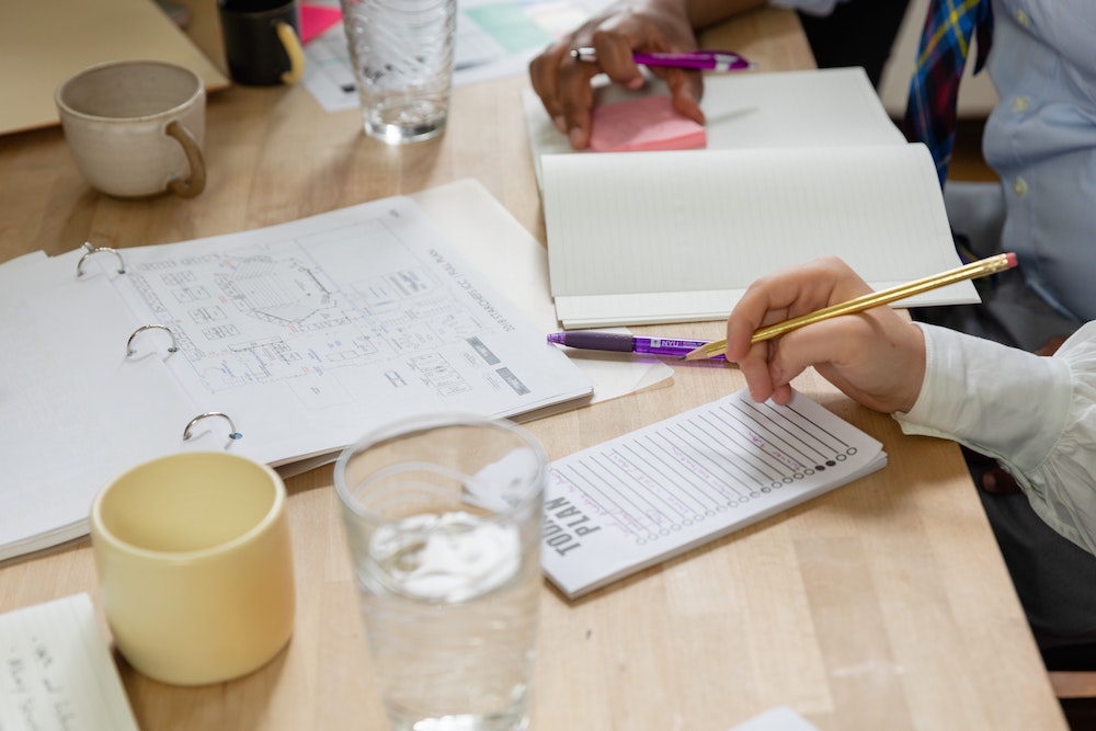 Transcription Services Image displaying two people at the the table, talking about work, brainstorming